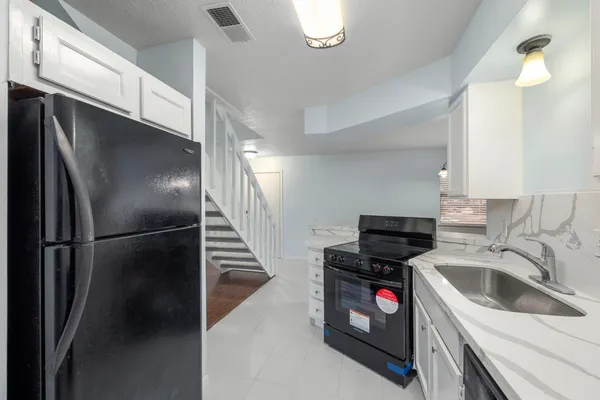 a kitchen with a sink appliances and cabinets