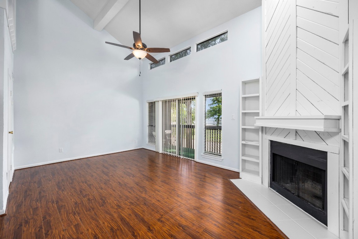 12755 Mill Ridge Drive, Unit 301 Cypress, TX 77429 - Photo 6 of 24 an empty room with wooden floor fireplace and windows
