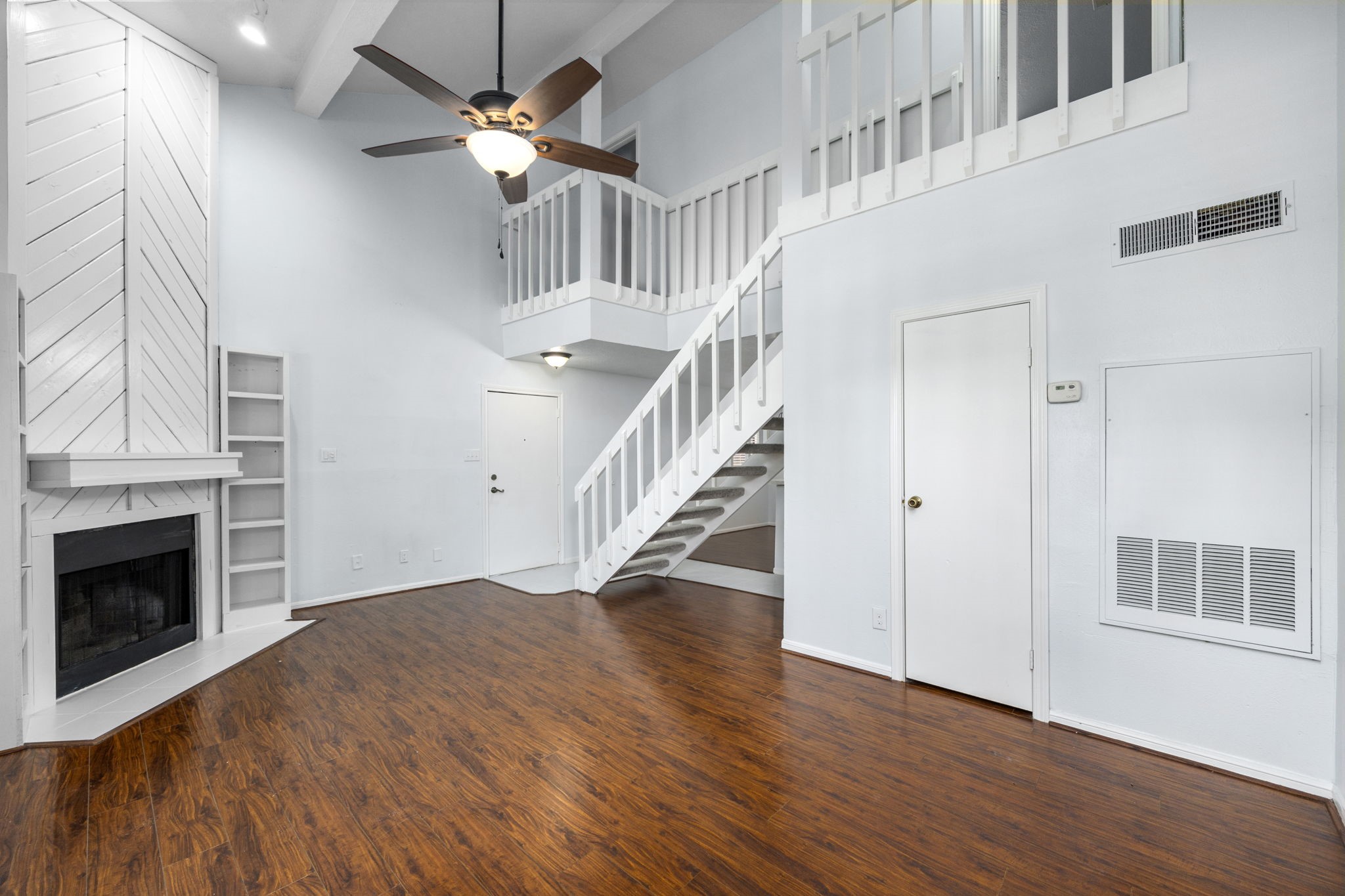 12755 Mill Ridge Drive, Unit 301 Cypress, TX 77429 - Photo 8 of 24 a view of an empty room with wooden floor fireplace and a window