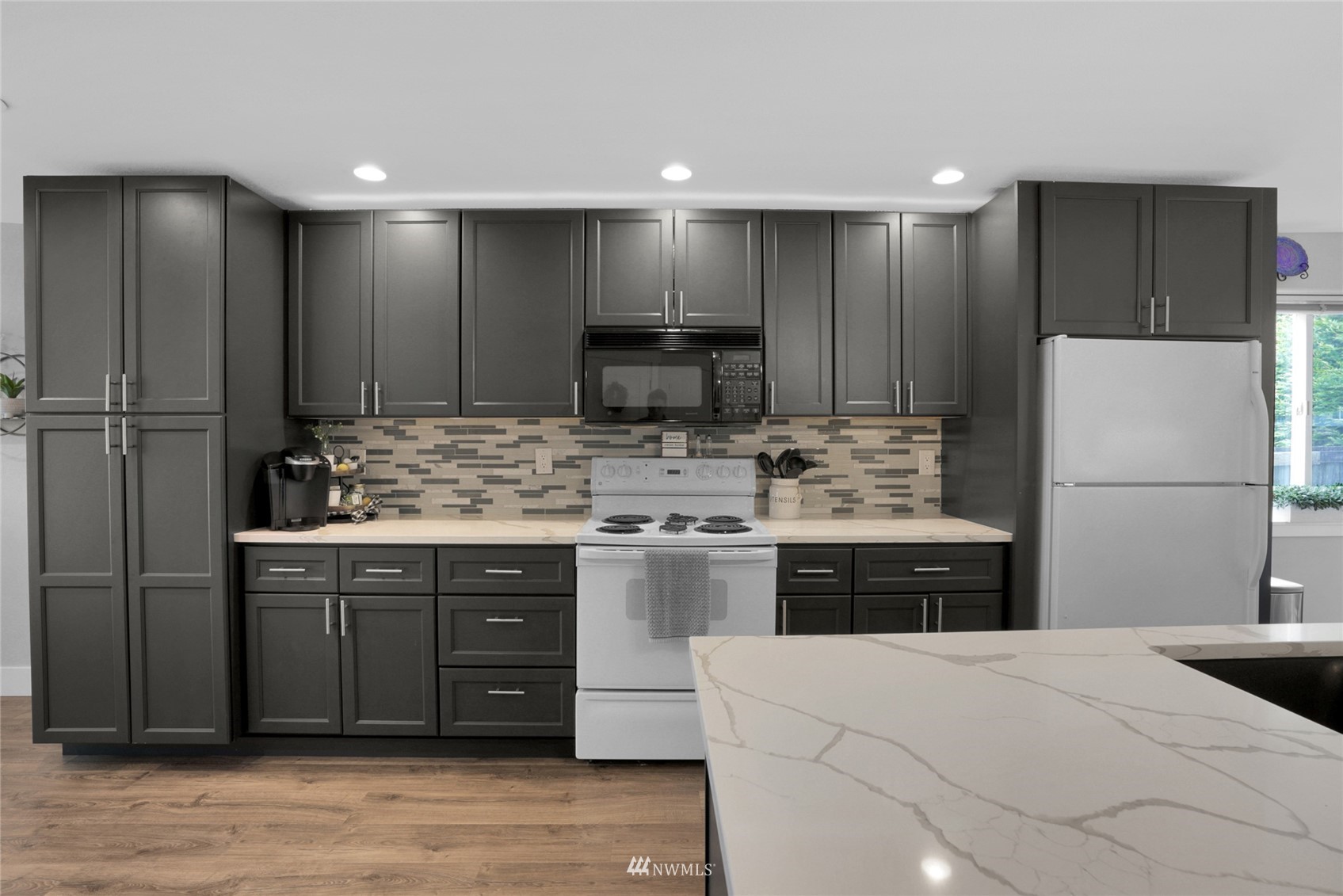 19303 Crown Ridge Boulevard Arlington, WA 98223 - Photo 11 of 30 a kitchen with kitchen island a sink stainless steel appliances and cabinets