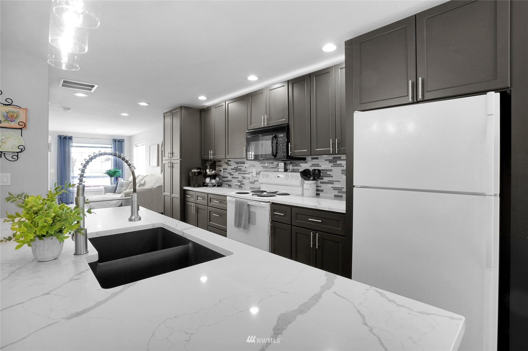 19303 Crown Ridge Boulevard Arlington, WA 98223 - Photo 12 of 30 a kitchen with stainless steel appliances a refrigerator sink and wooden cabinets