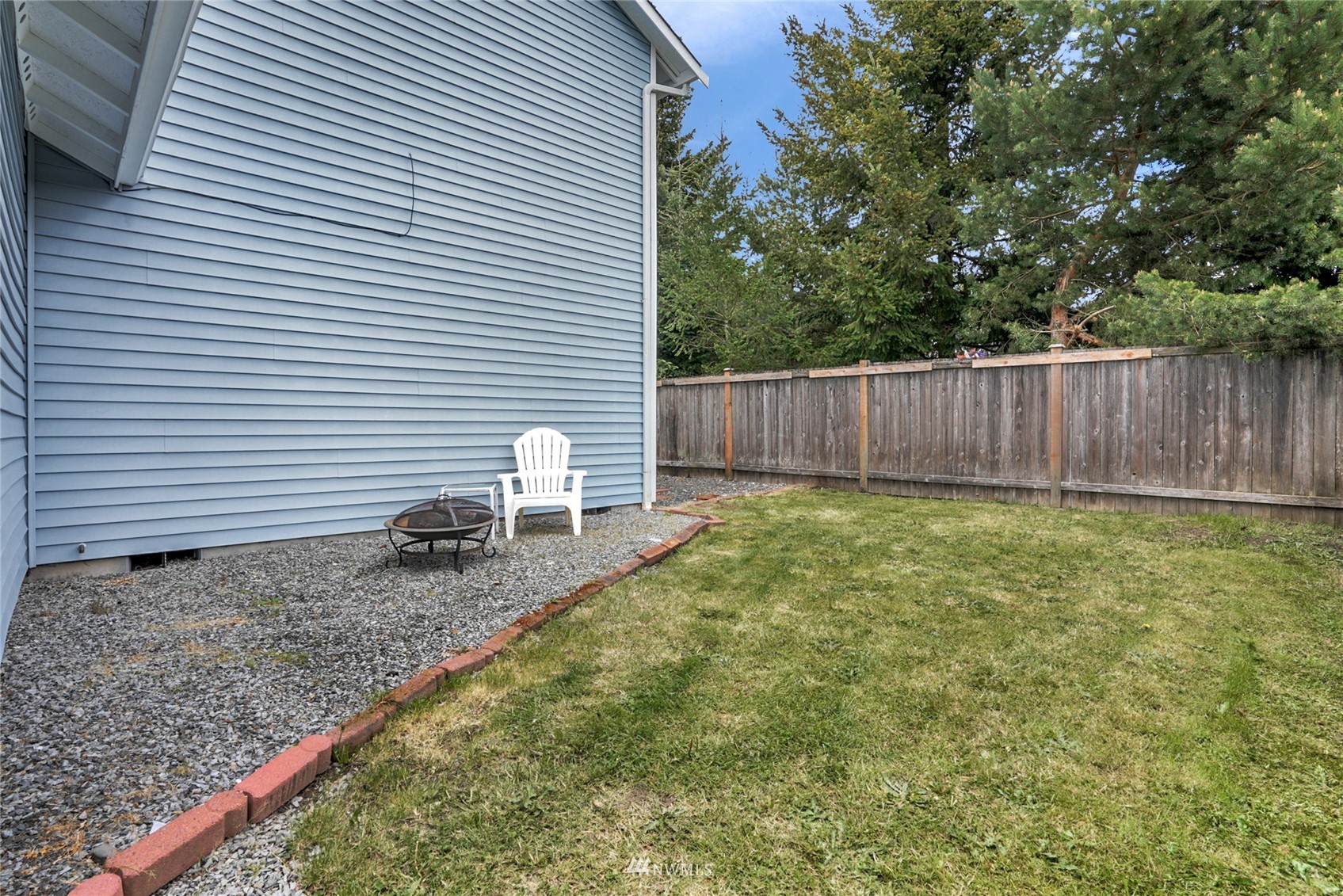 19303 Crown Ridge Boulevard Arlington, WA 98223 - Photo 30 of 30 a view of a backyard with a chair and wooden fence