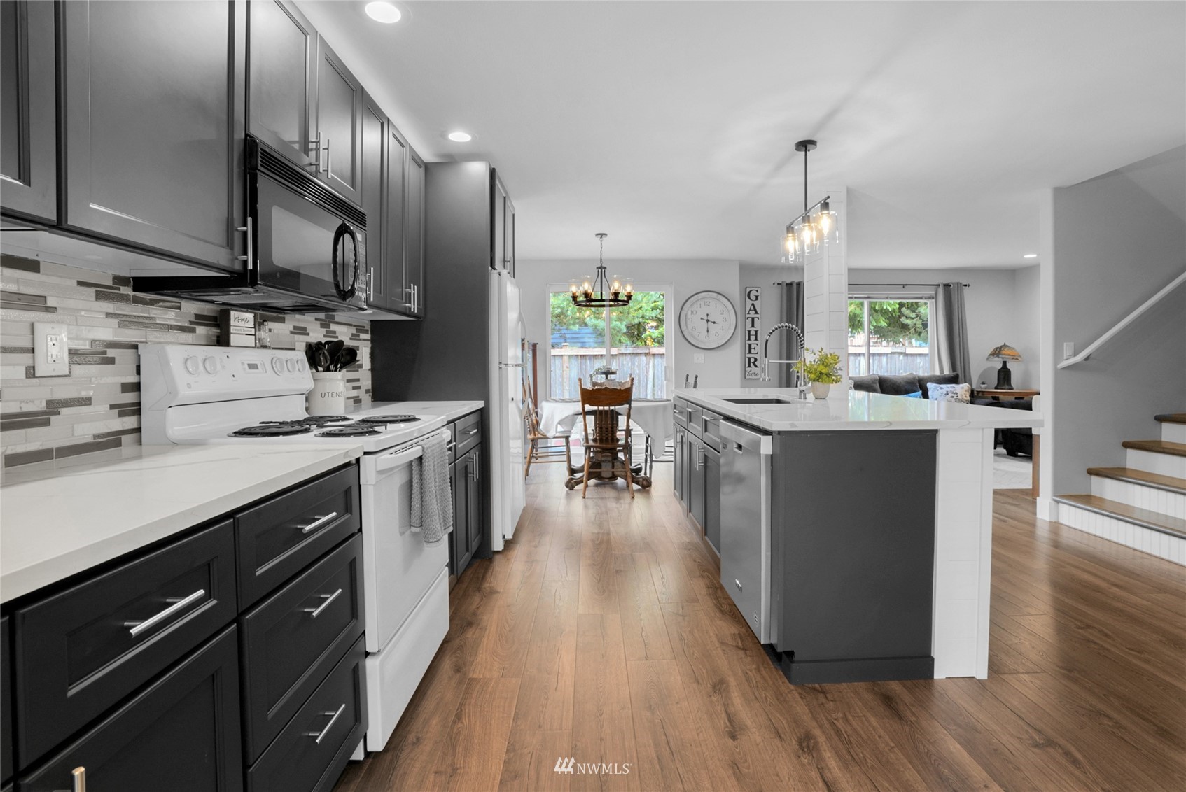 19303 Crown Ridge Boulevard Arlington, WA 98223 - Photo 10 of 30 a kitchen with stainless steel appliances kitchen island granite countertop a stove a sink dishwasher and a refrigerator