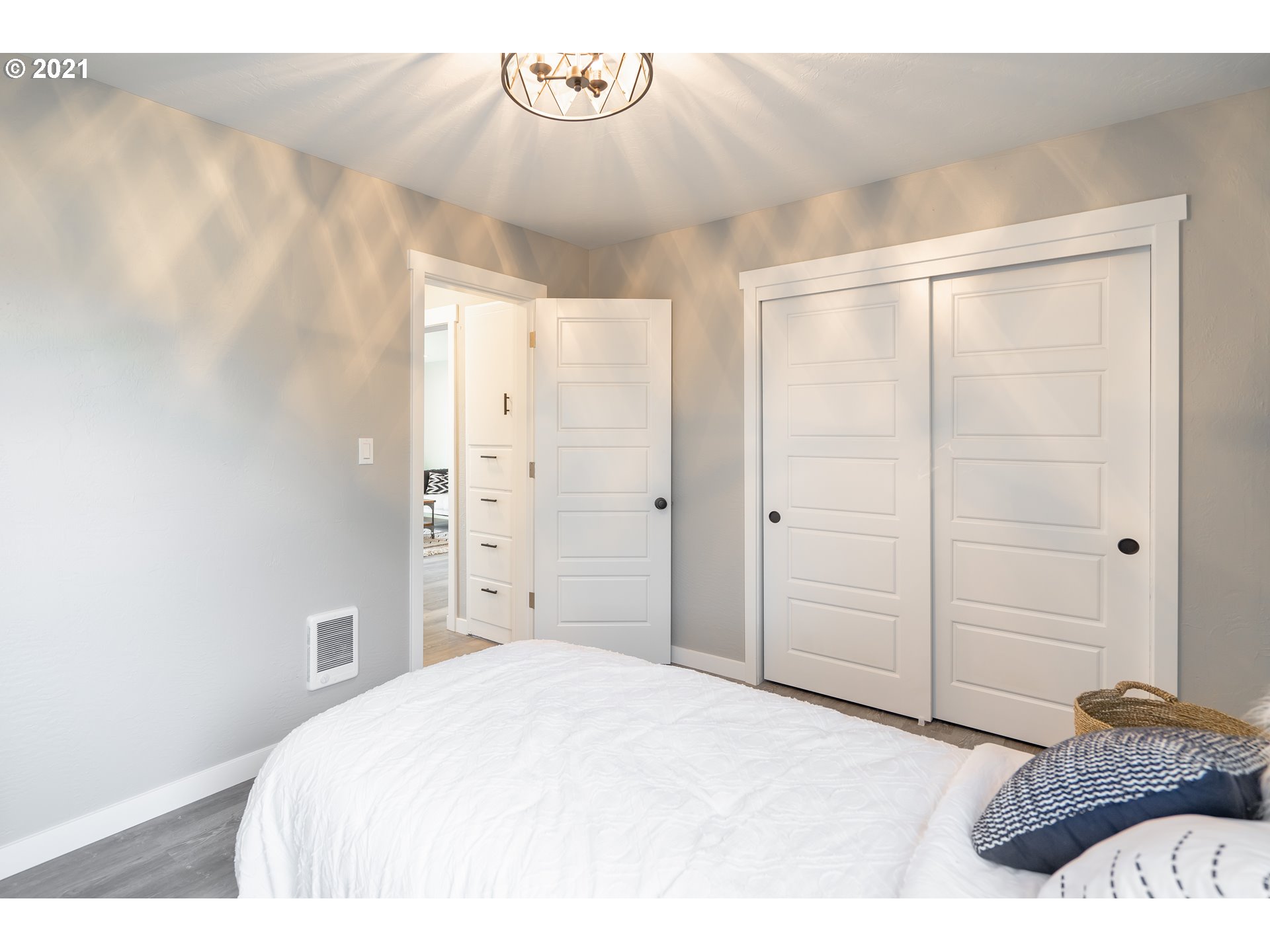 1214 L Street Springfield, OR 97477 - Photo 17 of 24 a spacious bedroom with a bed and a chandelier