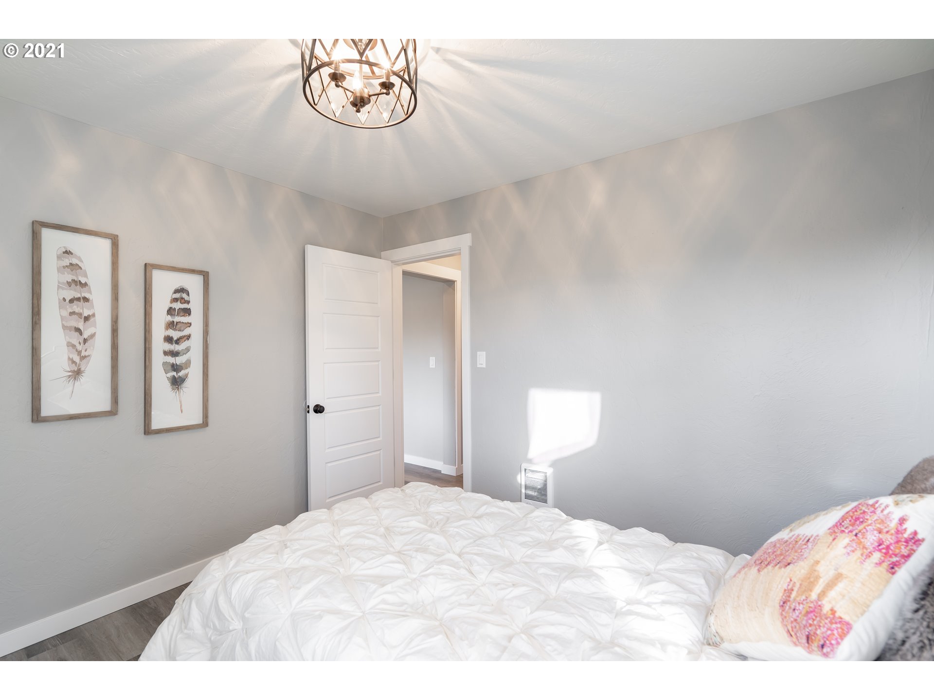 1214 L Street Springfield, OR 97477 - Photo 19 of 24 a bedroom with a bed and a chandelier