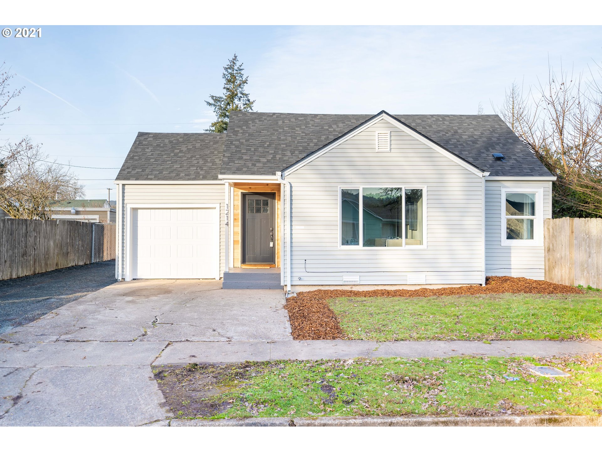 1214 L Street Springfield, OR 97477 - Photo 2 of 24 a front view of a house with a yard and garage