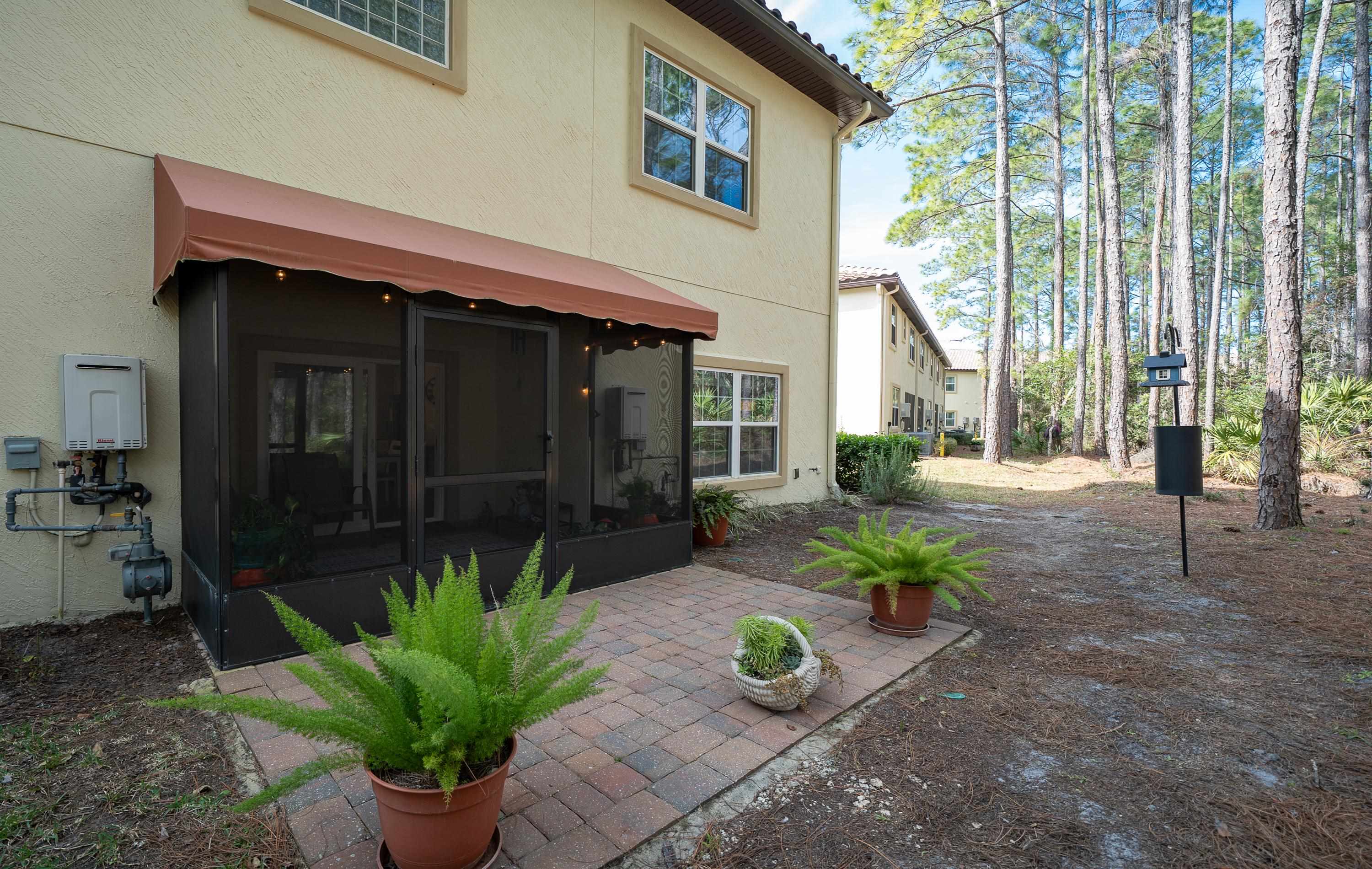 200 Grand Ravine Drive St. Augustine, FL 32086 - Photo 33 of 34 Back of house featuring stucco siding, a sunroom, and a patio