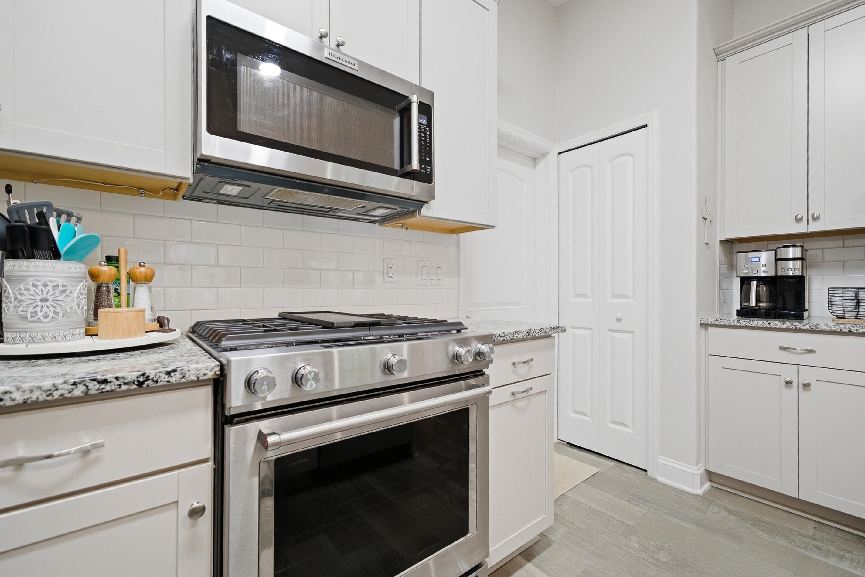 200 Grand Ravine Drive St. Augustine, FL 32086 - Photo 7 of 34 Kitchen featuring stainless steel appliances, decorative backsplash, light stone counters, white cabinetry, and light wood-style floors