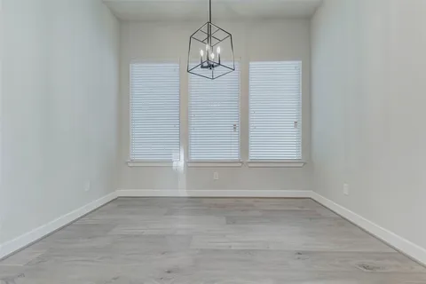 a view of empty room with window and wooden floor