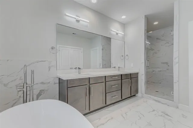 a bathroom with a double vanity sink mirror and shower