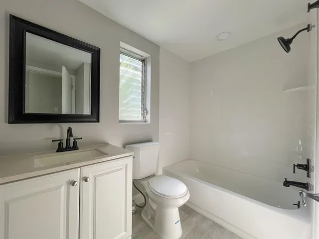 a bathroom with a toilet sink a mirror and shower