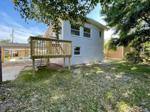 a view of a house with a yard and a bench
