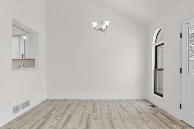 a view of a room with wooden floor and white walls