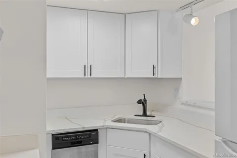 a kitchen with white cabinets and a sink