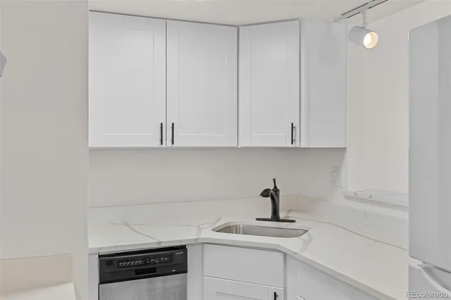 a kitchen with white cabinets and a sink