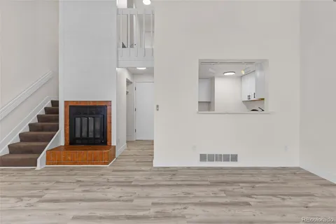 a view of a hallway with wooden floor and staircase
