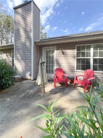 a view of a two chairs in the patio of the house