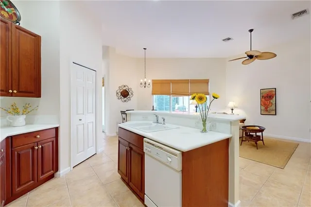 a kitchen with a stove a refrigerator a sink dishwasher with a dining table and chairs with wooden floor