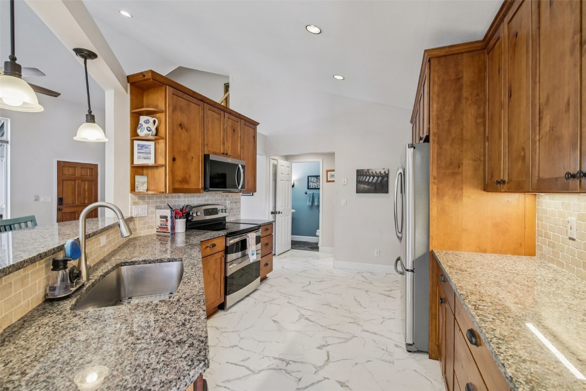 147 Blue Grouse Lane Silverthorne, CO 80498 - Photo 21 of 50 a kitchen with stainless steel appliances granite countertop a sink stove and refrigerator