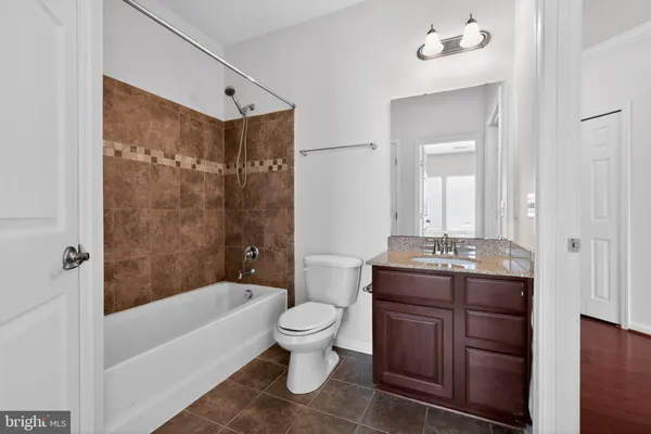 a bathroom with a granite countertop sink a toilet and bathtub