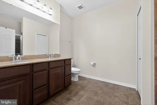a bathroom with a double vanity sink and a toilet
