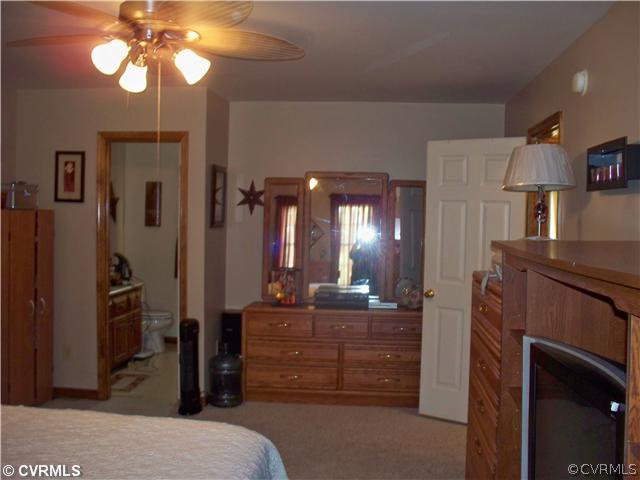 8001 Holdsworth Road Disputanta, VA 23842 - Photo 5 of 6 a bedroom with a bed and a chandelier