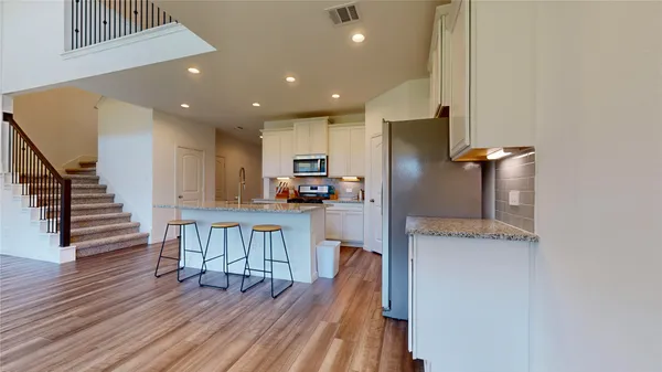 a kitchen with stainless steel appliances granite countertop a refrigerator and a stove top oven