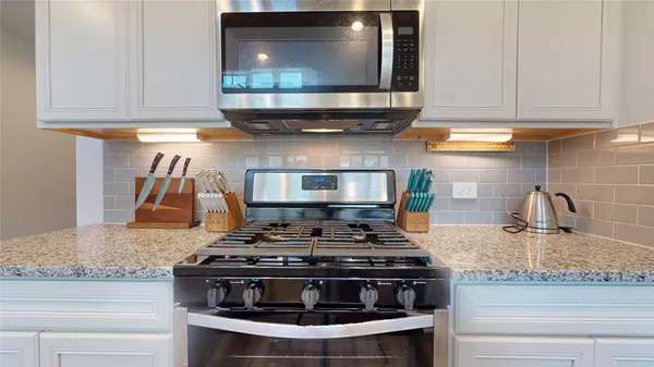 a kitchen with granite countertop a sink and a wooden floor