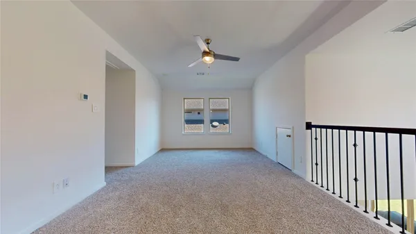 a view of a hallway with wooden floor and a bathroom