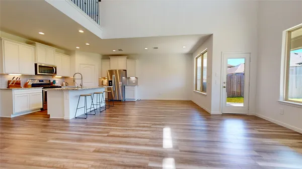a view of a kitchen with wooden floor and a refrigerator