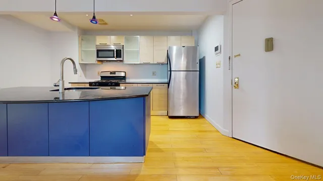 a kitchen with kitchen island a counter top space appliances and a sink