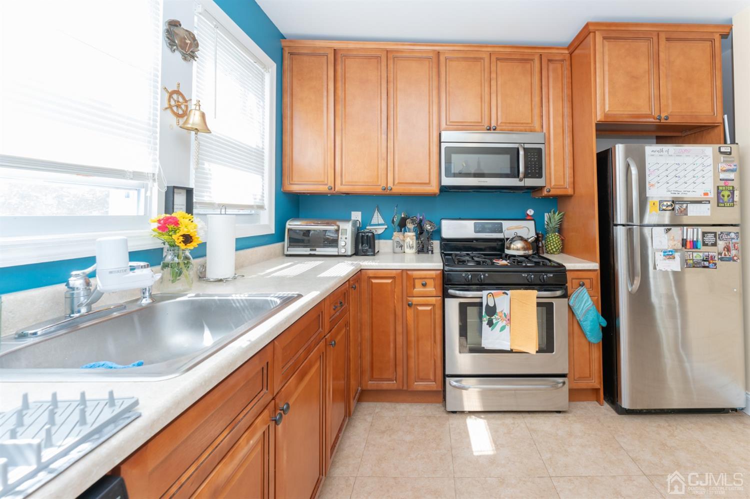 109 Stone Road Union Beach, NJ 07735 - Photo 10 of 21 a kitchen with stainless steel appliances granite countertop a refrigerator and a sink