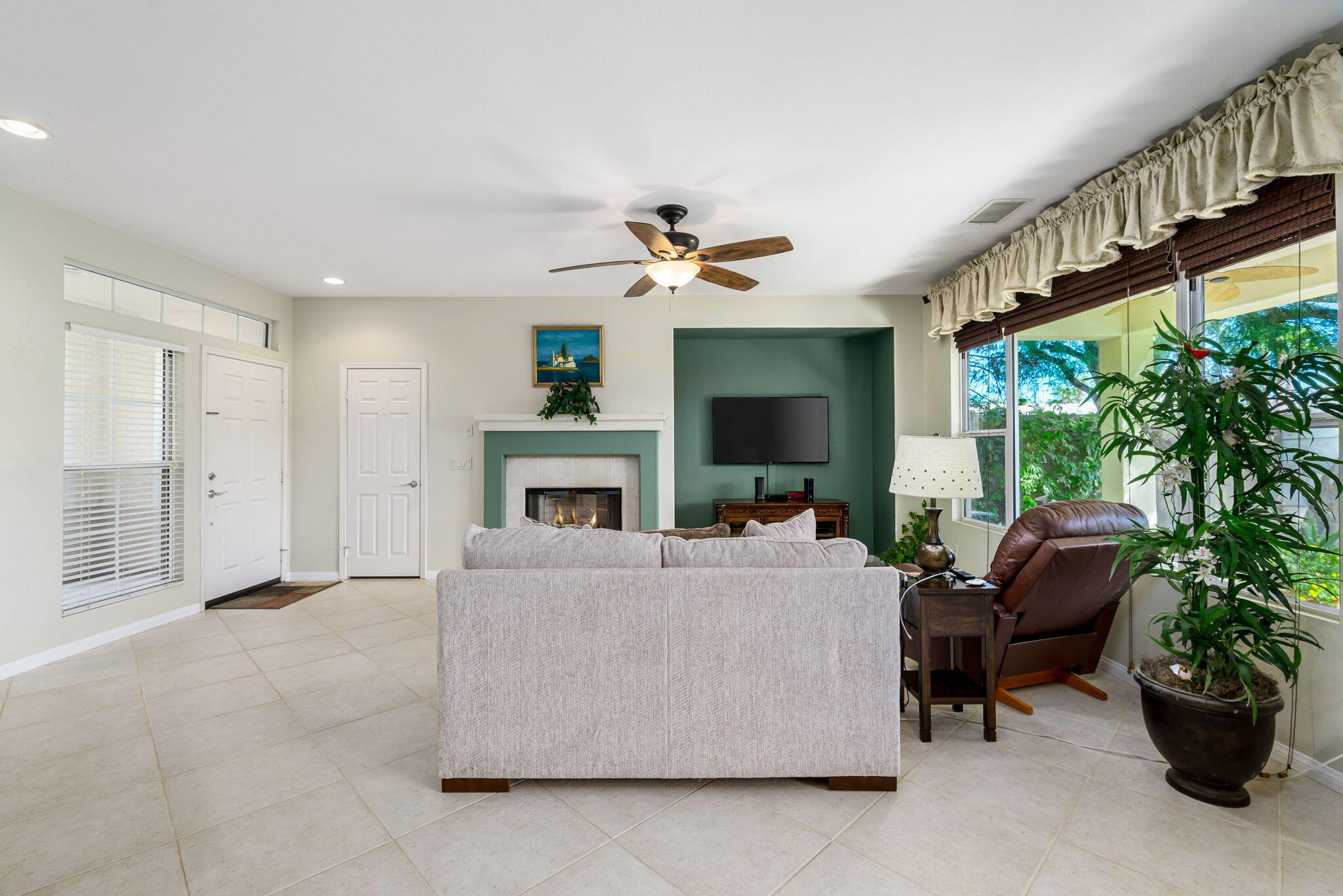 60246 Sweetshade Lane La Quinta, CA 92253 - Photo 12 of 76 a living room with furniture a fireplace and a potted plant