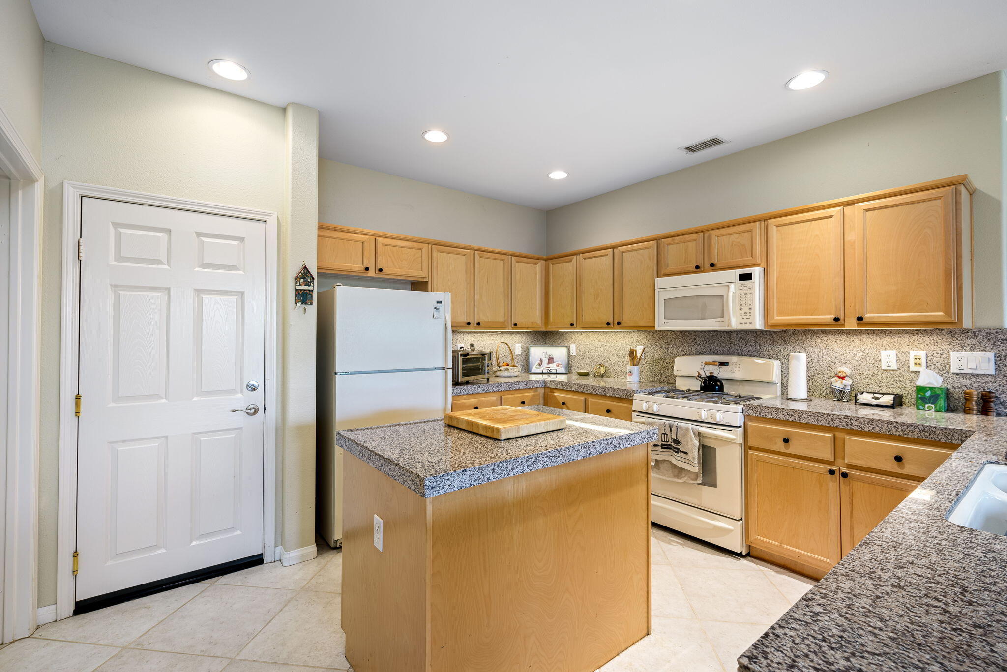 60246 Sweetshade Lane La Quinta, CA 92253 - Photo 17 of 76 a kitchen with cabinets a sink and appliances