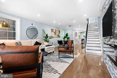 a living room with furniture a wooden floor and a potted plant