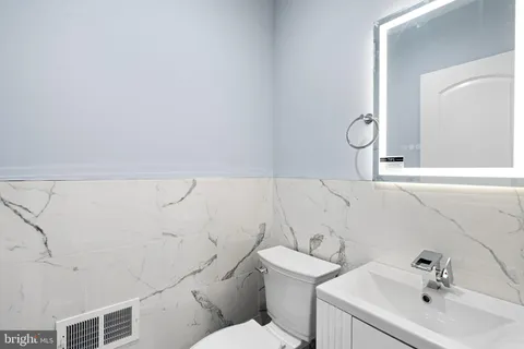 a bathroom with a sink mirror and toilet