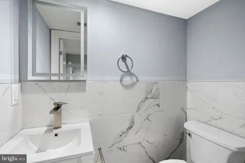 a bathroom with a sink a toilet and a mirror