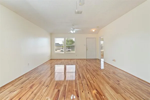 an empty room with windows and chandelier
