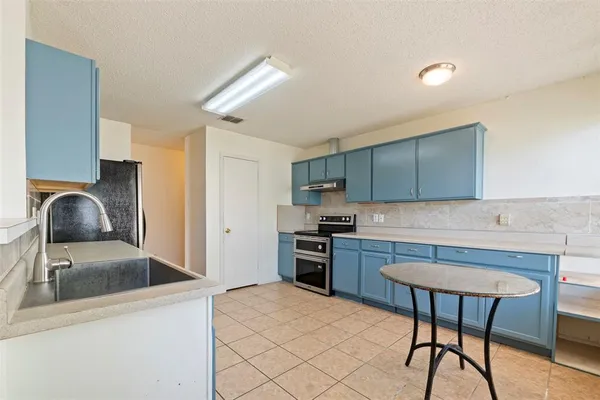 a kitchen with a stove a sink and a microwave