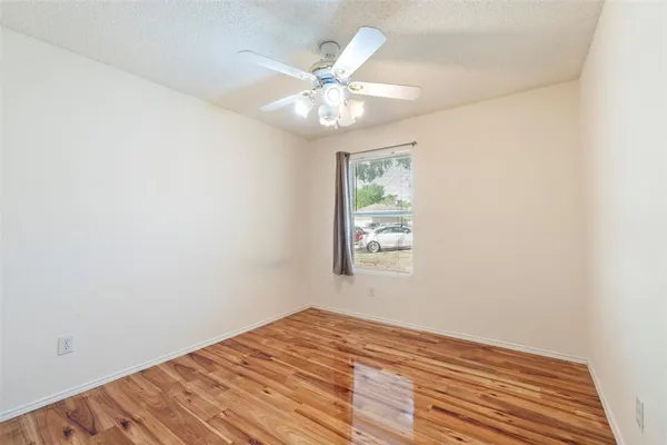 a view of a room with wooden floor and fan