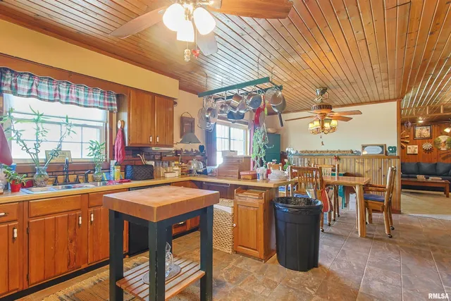 a view of a kitchen with kitchen island a stove a sink dishwasher and cabinets with wooden floor