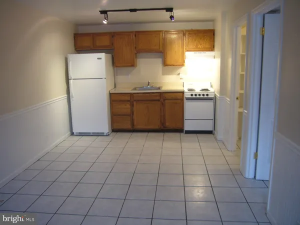 a kitchen with a refrigerator a stove top oven a sink and a window