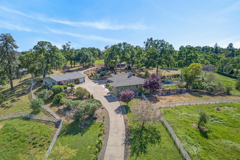5560 Ralston Way Placerville, CA 95667 - Photo 2 of 78 Expansive property featuring two residential structures, a concrete drive, abundant green space with mature trees, and white perimeter fencing