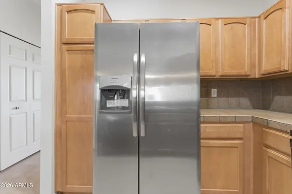 a close view of a refrigerator in kitchen and stainless steel appliances wooden cabinet