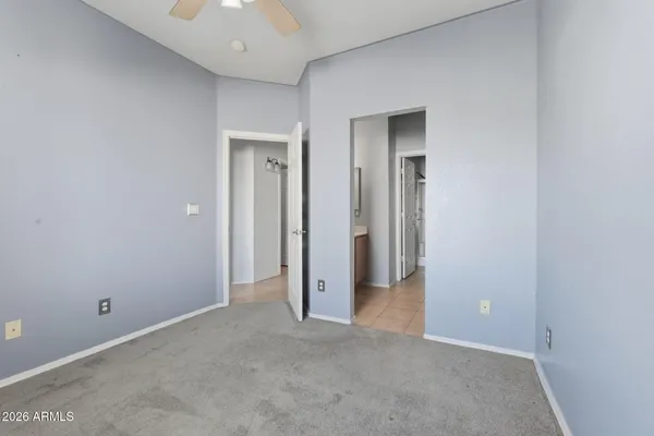 an empty room with closet and a chandelier fan