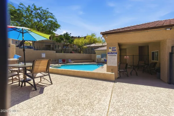 a patio with a table and chairs under an umbrella