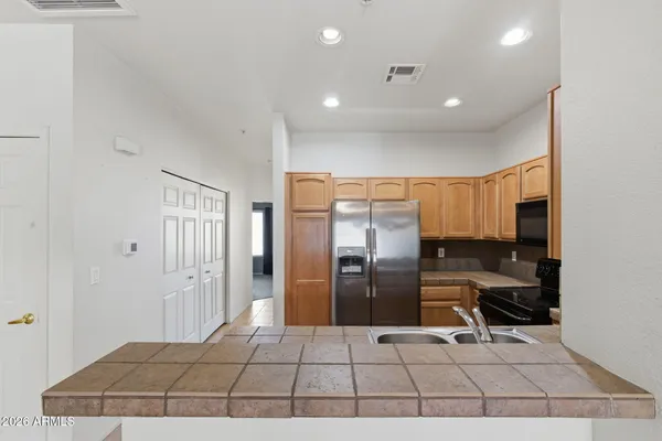 a kitchen with stainless steel appliances a refrigerator and a stove top oven