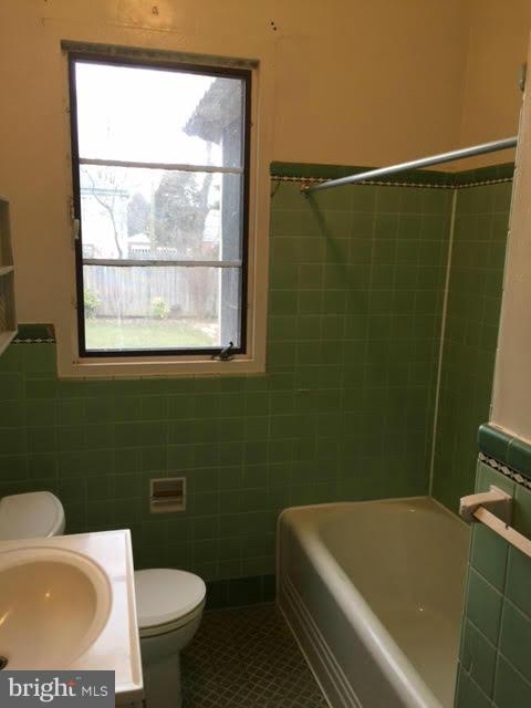 9904 Colesville Road Silver Spring, MD 20901 - Photo 15 of 23 a bathroom with a sink a toilet a mirror and a bathtub