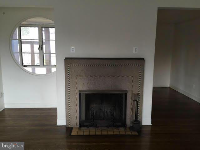 9904 Colesville Road Silver Spring, MD 20901 - Photo 7 of 23 an empty room with wooden floor fireplace and windows
