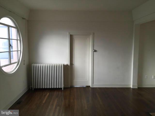 9904 Colesville Road Silver Spring, MD 20901 - Photo 10 of 23 an empty room with wooden floor mirror and windows